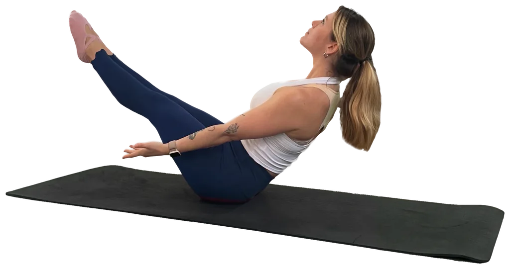 Alisa Appel hält die Pilates-Übung Boat Pose auf einer schwarzen Matte